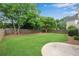 Manicured backyard featuring lush green grass, mature trees, and a well-maintained wooden fence at 1712 Bonnabel Ne Trce, Marietta, GA 30066