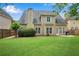 Wide backyard view of a home with a lush, green lawn, patio area, and mature landscaping at 1712 Bonnabel Ne Trce, Marietta, GA 30066