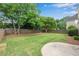 Manicured backyard featuring lush green grass, mature trees, and a well-maintained wooden fence at 1712 Bonnabel Ne Trce, Marietta, GA 30066