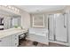 Bright bathroom featuring a tub, glass shower, double vanity and tile floors at 1712 Bonnabel Ne Trce, Marietta, GA 30066