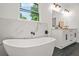 This modern bathroom showcases a freestanding tub with black fixtures, marble accents, and a sleek double vanity at 2926 5Th Sw St, Atlanta, GA 30315