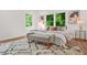 This bedroom features three bright windows, a modern rug, and a stylish upholstered bench at the foot of the bed at 2926 5Th Sw St, Atlanta, GA 30315