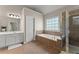 Bathroom features tile flooring, double vanity, a bathtub, and a glass enclosed shower at 2100 Willshire Gln, Alpharetta, GA 30009