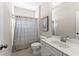 Well-lit bathroom featuring tile flooring, a shower, a white sink with vanity, and decorative wall art at 2100 Willshire Gln, Alpharetta, GA 30009