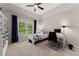 Bright bedroom features a ceiling fan, a window with blue curtains, and a desk with a computer setup at 2100 Willshire Gln, Alpharetta, GA 30009