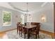 Elegant dining room featuring tray ceiling, chandelier, hardwood floors, and windows letting in natural light at 2100 Willshire Gln, Alpharetta, GA 30009