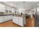 Bright kitchen features white cabinets, hardwood floors, granite counters, and an island with stainless appliances at 2100 Willshire Gln, Alpharetta, GA 30009