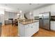Bright kitchen featuring white cabinets, stainless steel appliances, and island that opens to the living room at 2100 Willshire Gln, Alpharetta, GA 30009