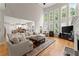 Spacious living room featuring high windows, a fireplace, and an open layout leading into the kitchen and dining area at 2100 Willshire Gln, Alpharetta, GA 30009