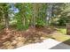 View of the lush, tree-filled backyard and patio area, shaded by mature trees at 3425 Sable Chase Ln, South Fulton, GA 30349