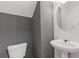 A half-bath features a pedestal sink, round mirror, and gray accent wall at 3425 Sable Chase Ln, South Fulton, GA 30349