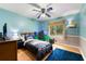 Comfortable bedroom with wood floor, ceiling fan, and large window letting in natural light at 486 Buttercup Trl, Lawrenceville, GA 30046