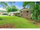 Traditional brick home on a grassy, gently sloping lot with mature trees and a covered front porch at 486 Buttercup Trl, Lawrenceville, GA 30046