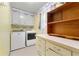 Efficient laundry room with storage cabinets, washer, and dryer for added convenience at 486 Buttercup Trl, Lawrenceville, GA 30046