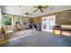 Enclosed sunroom with brick accent wall, ceiling fans, and natural light from multiple windows offering backyard views at 486 Buttercup Trl, Lawrenceville, GA 30046