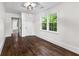 Bedroom with hardwood floors, natural light, and view to hallway at 1730 Lee Peters Rd, Loganville, GA 30052