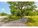 Long paved driveway leading to a home surrounded by mature trees and green lawn at 1730 Lee Peters Rd, Loganville, GA 30052
