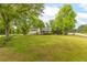 Home exterior highlighting a front lawn, mature trees, and driveway at 1730 Lee Peters Rd, Loganville, GA 30052