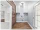 Well-lit laundry room featuring wood paneling, storage cabinets, and tile flooring at 1730 Lee Peters Rd, Loganville, GA 30052