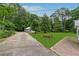 Backyard featuring a well-maintained lawn, privacy trees, a shed, and a brick patio at 1926 Parkwood Rd, Snellville, GA 30078