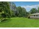 The backyard has a large grassy area with mature trees, providing a peaceful, natural setting at 1926 Parkwood Rd, Snellville, GA 30078