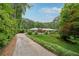 Charming home with a long driveway, lush lawn, mature trees, and a pop of color with a red front door at 1926 Parkwood Rd, Snellville, GA 30078
