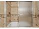 Tile shower with glass doors, accented with a decorative tile border at 1926 Parkwood Rd, Snellville, GA 30078