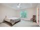 Bright primary bedroom with large windows offering a view of the outdoors and a tray ceiling with ceiling fan at 2715 Braemore Gln, Powder Springs, GA 30127