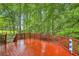 Exterior deck surrounded by lush greenery offers a tranquil retreat in a wooded area at 2715 Braemore Gln, Powder Springs, GA 30127