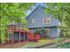 Two-story home features a two-story deck overlooking the backyard, landscaping, and blue siding at 2715 Braemore Gln, Powder Springs, GA 30127