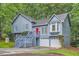 Two-story home features blue siding, a red front door, a two-car garage, and mature trees at 2715 Braemore Gln, Powder Springs, GA 30127