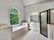 Large bathroom with a tub, step-in shower and beautiful window view at 3832 Cherry Ridge Blvd, Decatur, GA 30034