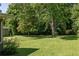Spacious backyard featuring a lush lawn and mature trees offering shade and privacy at 762 Rockbridge Nw Rd, Lilburn, GA 30047