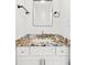 Bathroom with an elegant vanity, white cabinets, granite counters, a white vessel sink, and stylish accessories at 762 Rockbridge Nw Rd, Lilburn, GA 30047