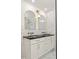Modern bathroom with double sinks, marble countertops, and white cabinetry with gold hardware at 762 Rockbridge Nw Rd, Lilburn, GA 30047