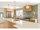 Bright kitchen with quartz countertops, stainless appliances, modern lighting and light wood cabinetry at 762 Rockbridge Nw Rd, Lilburn, GA 30047