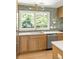 Close up of kitchen cabinets, sink, and countertops and backsplash, stainless dishwasher and lighting fixtures at 762 Rockbridge Nw Rd, Lilburn, GA 30047