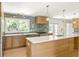 Bright modern kitchen featuring custom wood cabinets, stainless appliances, and a large island with pendant lighting at 762 Rockbridge Nw Rd, Lilburn, GA 30047