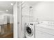Laundry room with washer, dryer, and wire shelving, with access to other living areas at 762 Rockbridge Nw Rd, Lilburn, GA 30047