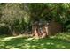Backyard featuring a weathered shed with a small window, surrounded by lush greenery at 762 Rockbridge Nw Rd, Lilburn, GA 30047