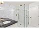 Luxurious marble tiled shower with glass enclosure and gold fixtures in the updated bathroom at 762 Rockbridge Nw Rd, Lilburn, GA 30047