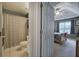 This bathroom features a shower with a gray checkered curtain next to a bedroom with a fan at 1047 Taso Trl, Acworth, GA 30101