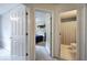 Hallway view showing doorway into the bath and bedroom with tan walls and neutral carpeting at 1047 Taso Trl, Acworth, GA 30101