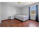 Cozy bedroom features hardwood floors, a bed with patterned bedding, and a window with dark blue curtains at 1312 Brandl Dr, Marietta, GA 30008