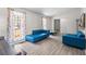 Bright living room with wood-look floors, offering a view to an outdoor deck and showcasing a modern blue sofa at 1312 Brandl Dr, Marietta, GA 30008