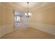 Open-concept dining area with decorative wainscoting and chandelier, flowing into living space with fireplace at 223 Glens Loop, Woodstock, GA 30188