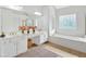 Bright bathroom with double vanity, large mirror, soaking tub, and decorative window at 2372 Oberon Se Walk, Smyrna, GA 30080