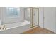 Bathroom showcasing a glass enclosed shower, soaking tub, and decorative window at 2372 Oberon Se Walk, Smyrna, GA 30080