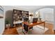 Stylish home office featuring a large desk, built-in bookcase, and hardwood floors for a professional workspace at 2372 Oberon Se Walk, Smyrna, GA 30080