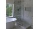Contemporary bathroom showcasing a freestanding tub, glass-enclosed shower, and marble-look tile at 4220 Glad Morning Dr, College Park, GA 30349
